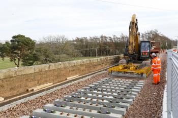 sleepers being laid on the red bridge viaduct over the River Tweed just short of the terminus at Tweedbank on 4th Feb 2015