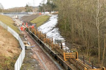 Rails are dragged forward from the train onto the new sleepers approximately 1km from Tweedbank.