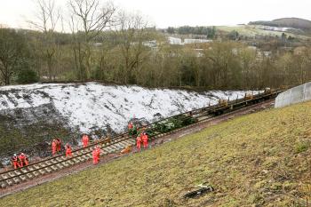 Rails are dragged forward from the train onto the new sleepers approximately 1km from Tweedbank.
