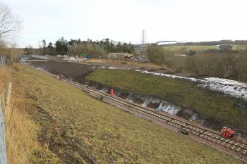 Rails are dragged forward from the train onto the new sleepers approximately 1km from Tweedbank.