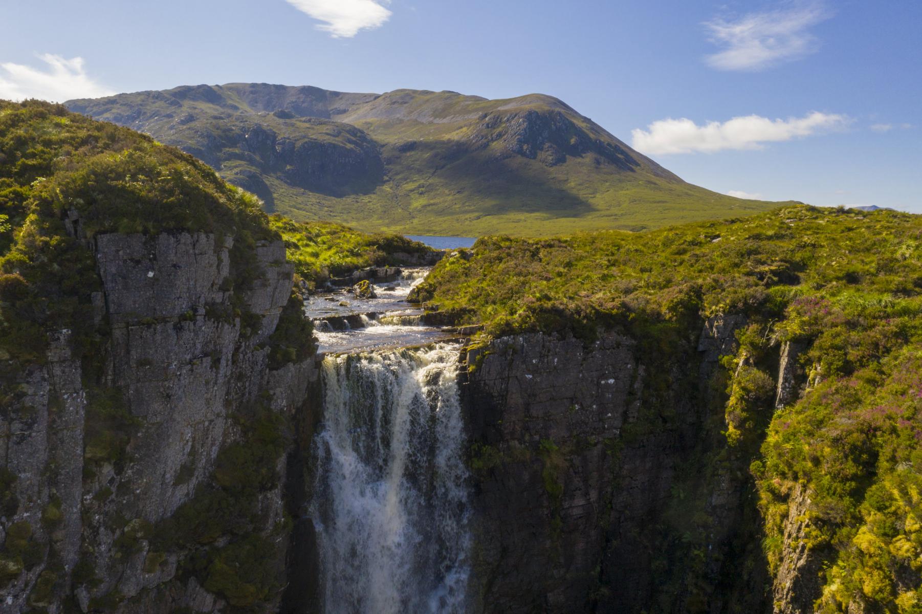 Drone Close-up of falls flowing into Allt Chrànaidh, flowing out of Loch na Gainmhich (Gan-vig) - Glas Beinn (Background) Assynt, Sutherland Drone Close-up of falls flowing into Allt Chrànaidh, flowing out of Loch na Gainmhich (Gan-vig) - Glas Beinn (Background) Assynt, Sutherland